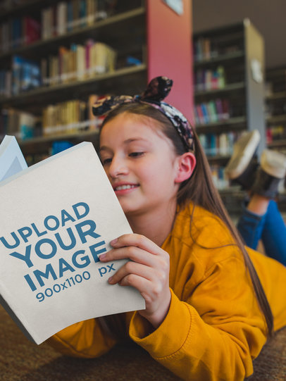 Happy Girl Reading a Book Mockup Lying on the Library's Floor