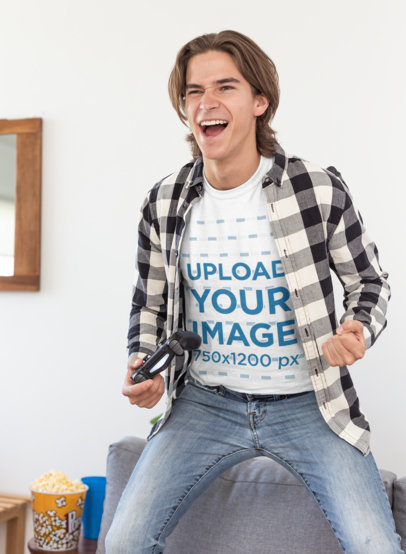 T-Shirt Mockup of a Thrilled Gamer Standing on His Couch